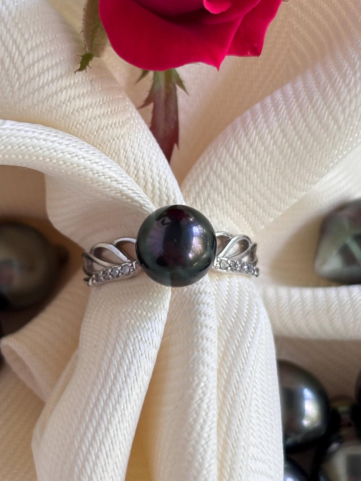 Black pearl ring on a white fabric background