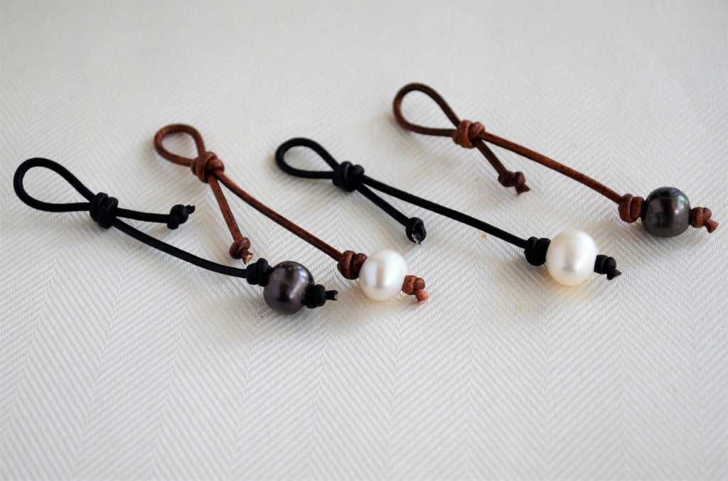 Four necklace/bracelet pearl leather extenders on a white background