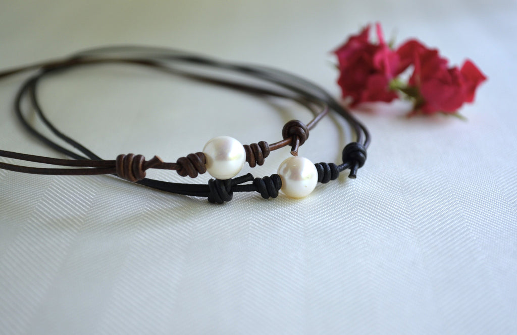Necklace with pearls on a white background with pink flowers