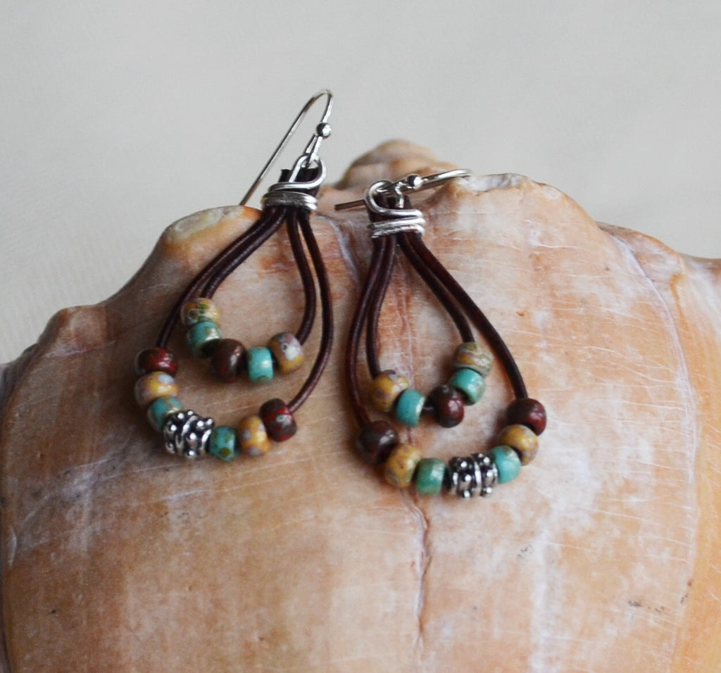 Beaded earrings on a shell with a neutral background