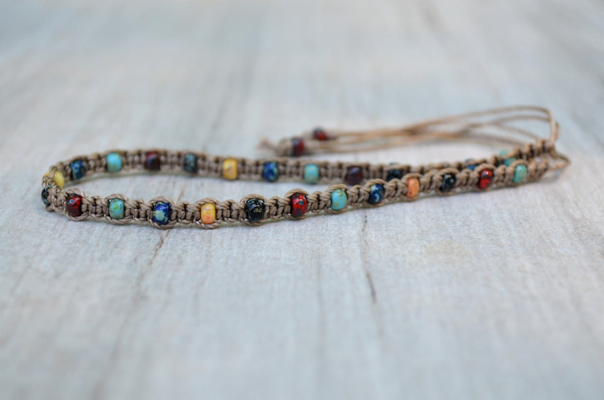 Beaded anklet with colorful stones on a textured surface