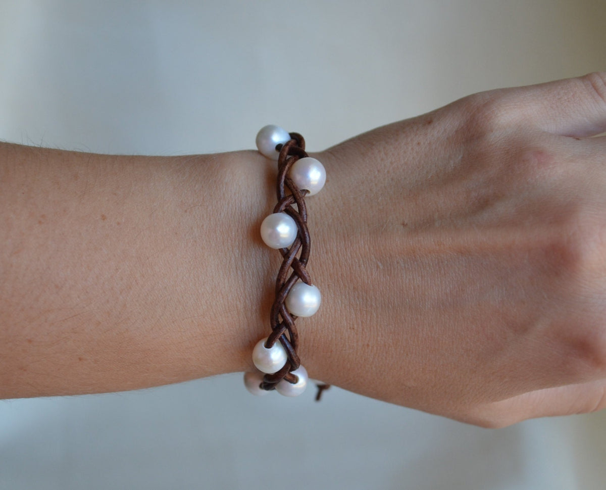 Pearl bracelet on a wrist with a plain background