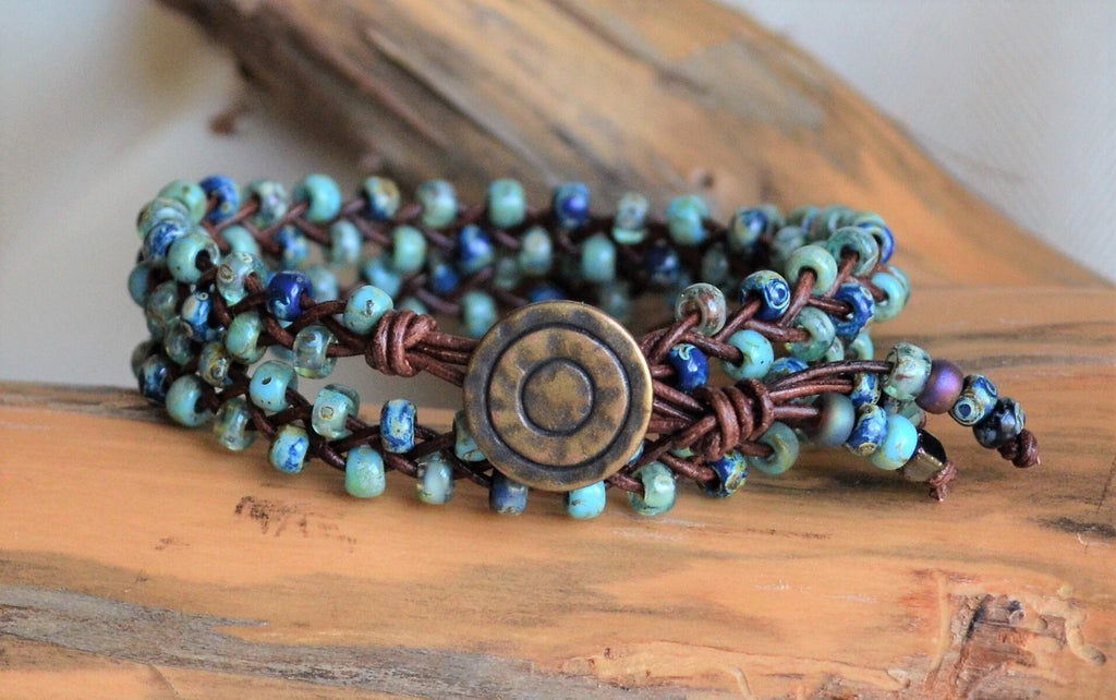 Multistrand beaded bracelet with a large central button on a wooden surface