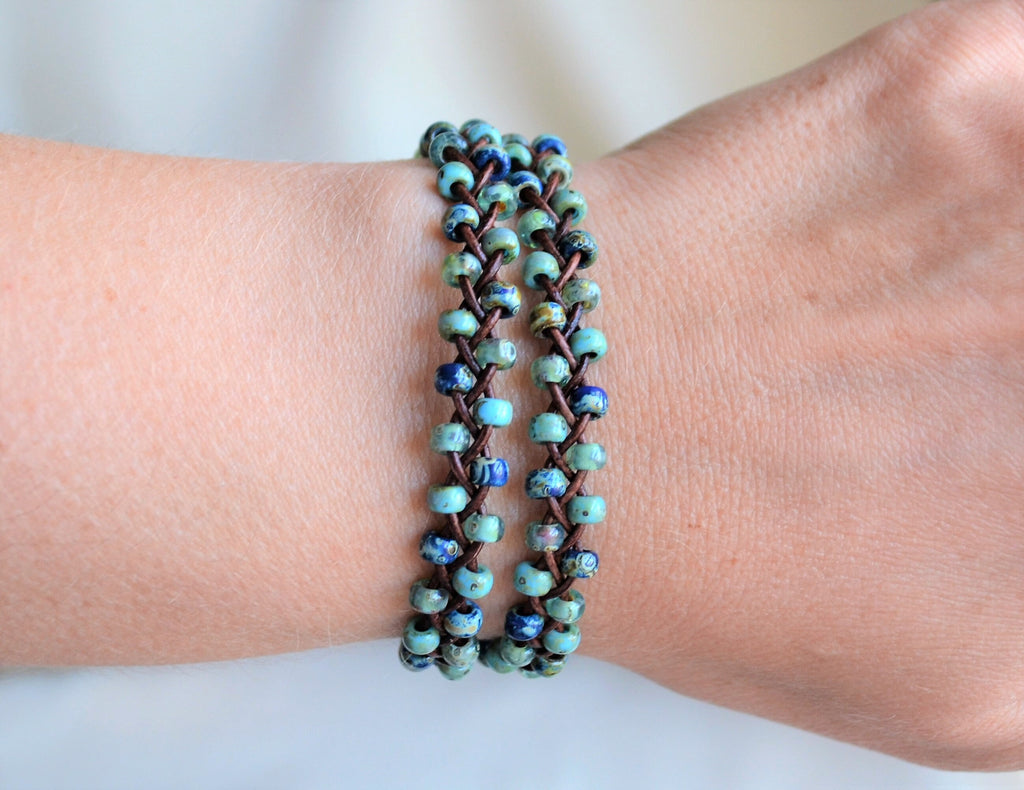 Two wrap beaded bracelet on a wrist against a neutral background