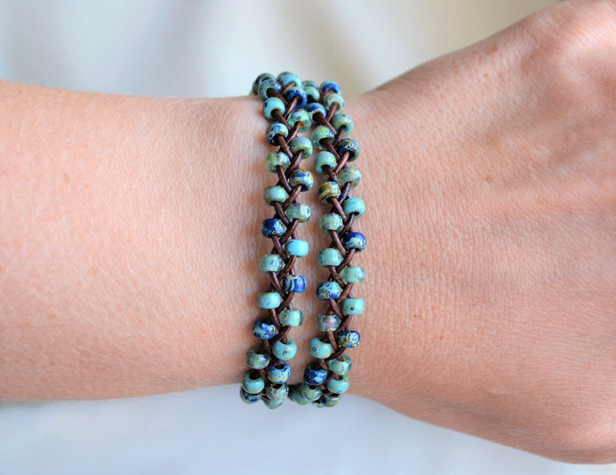 Two wrap beaded bracelet on a wrist against a neutral background