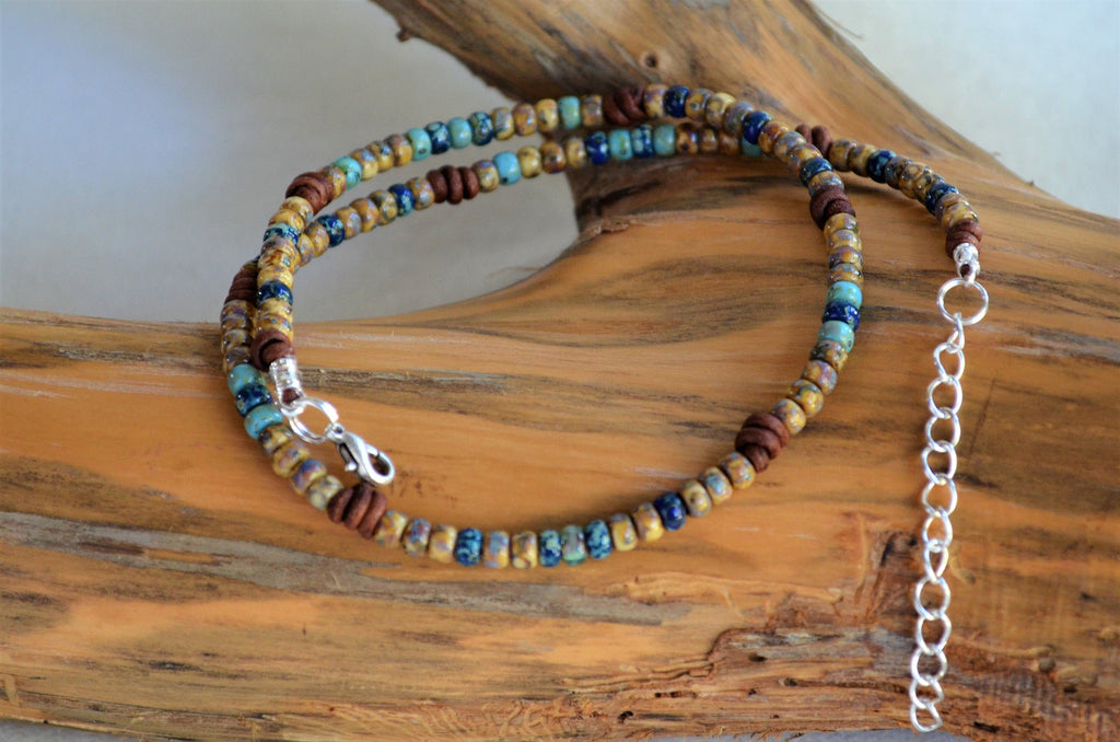 Multicolored beaded short necklace with a silver clasp on a wooden surface