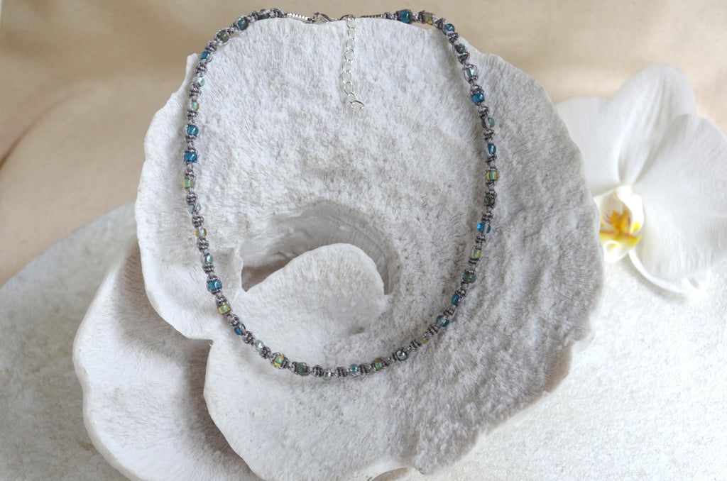 Necklace with blue beads on a white stone surface
