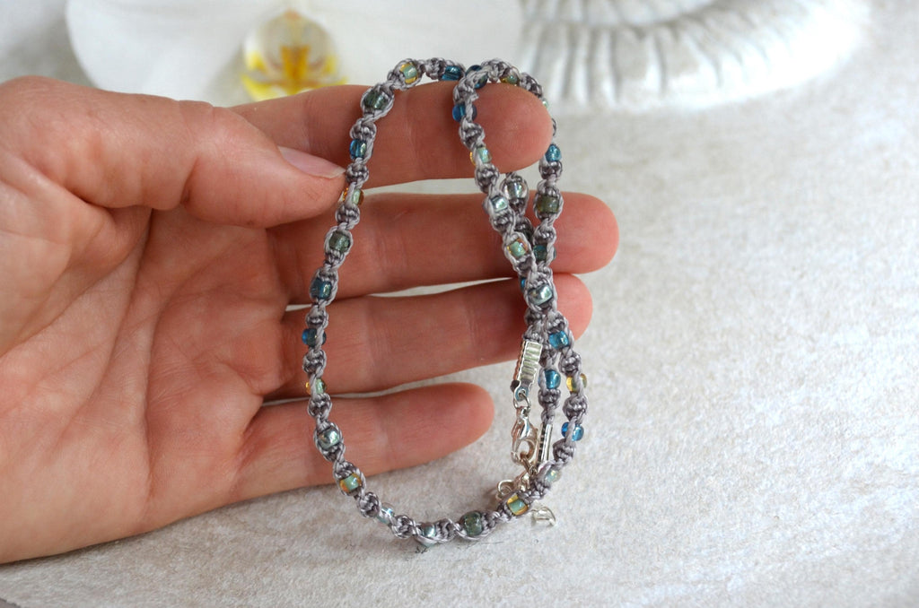 Beaded necklace held in a hand on a light background
