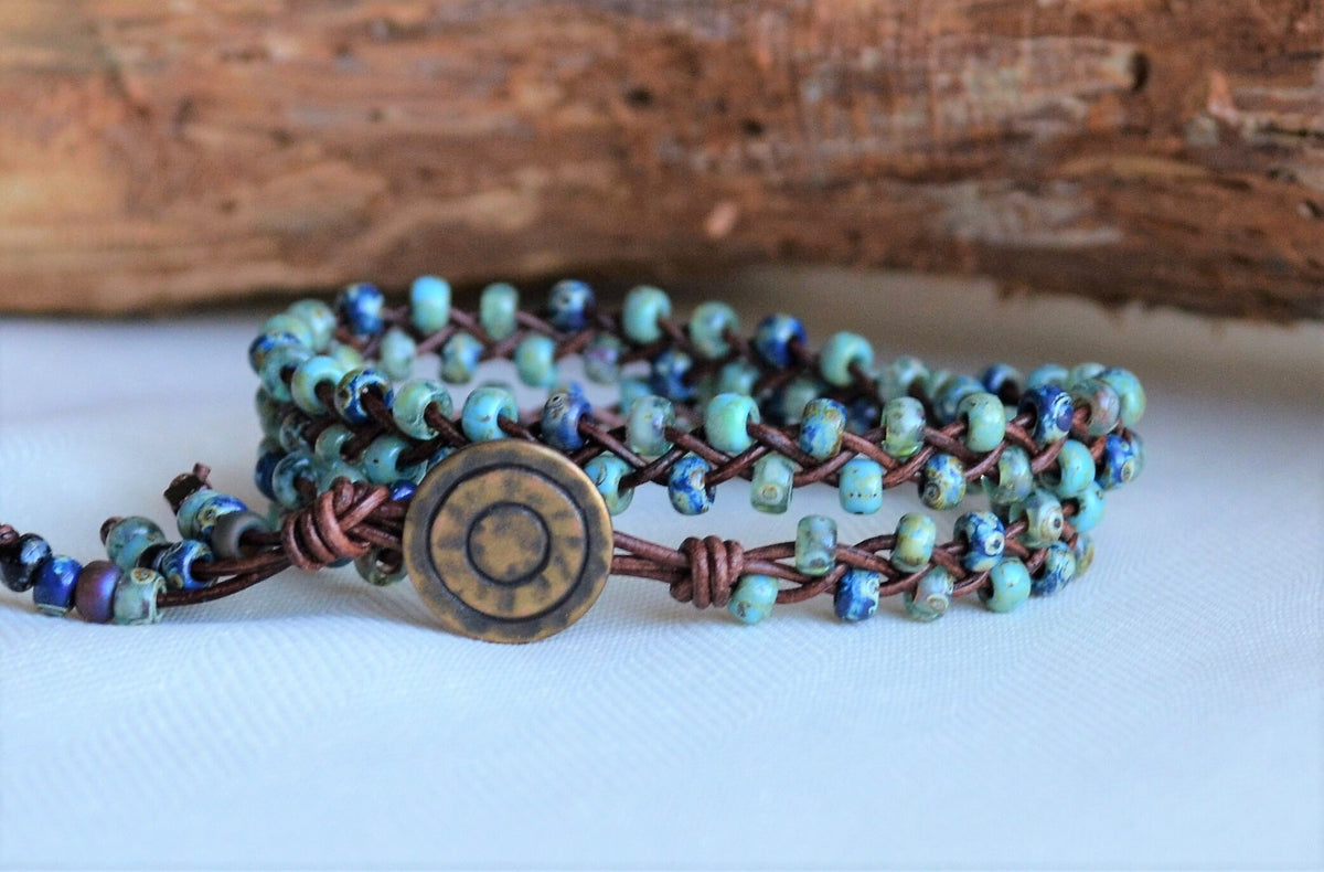 Multistrand bracelet with blue and brown beads on a white surface with wooden background