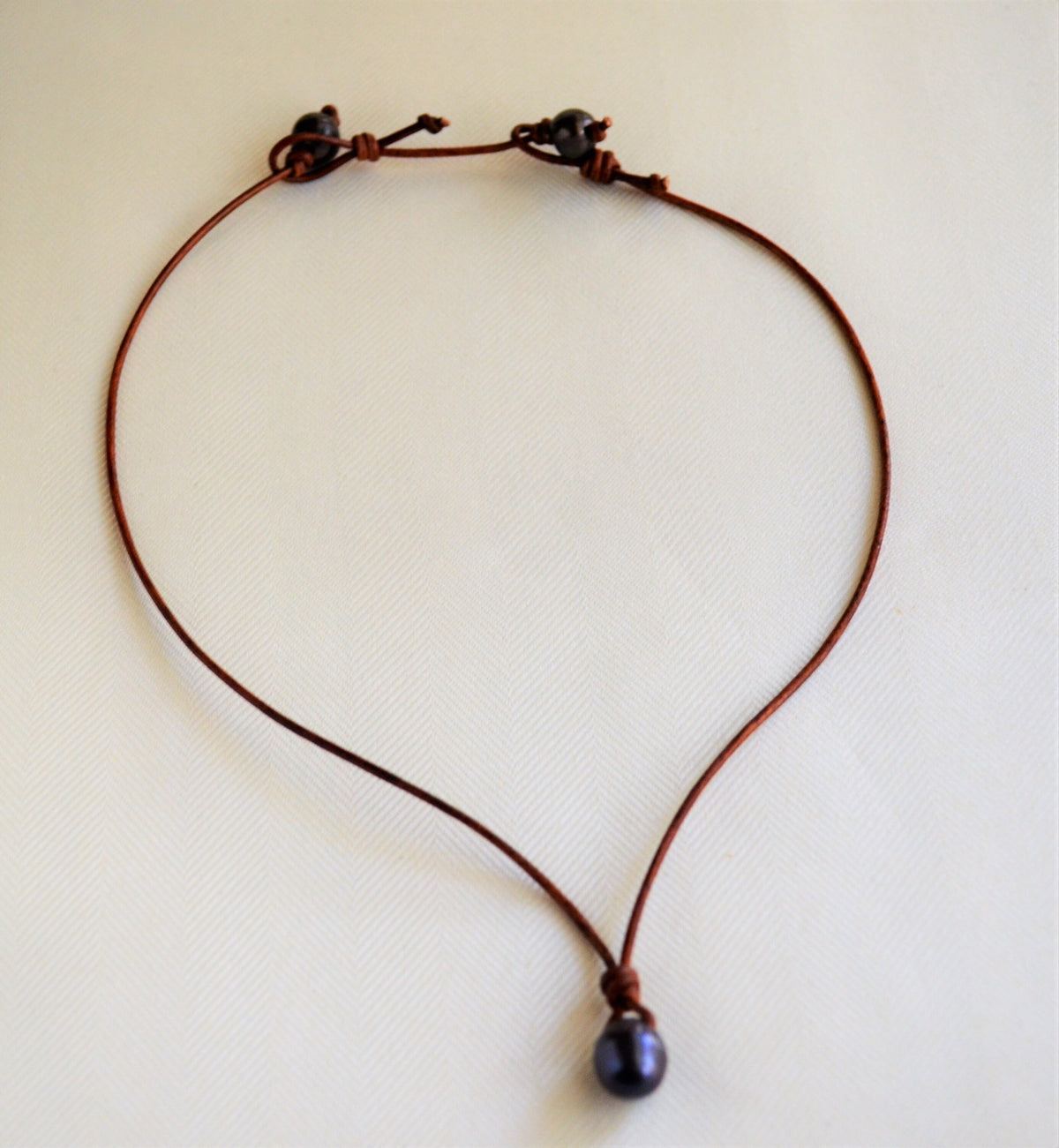 Necklace with pearl leather extender on a light background