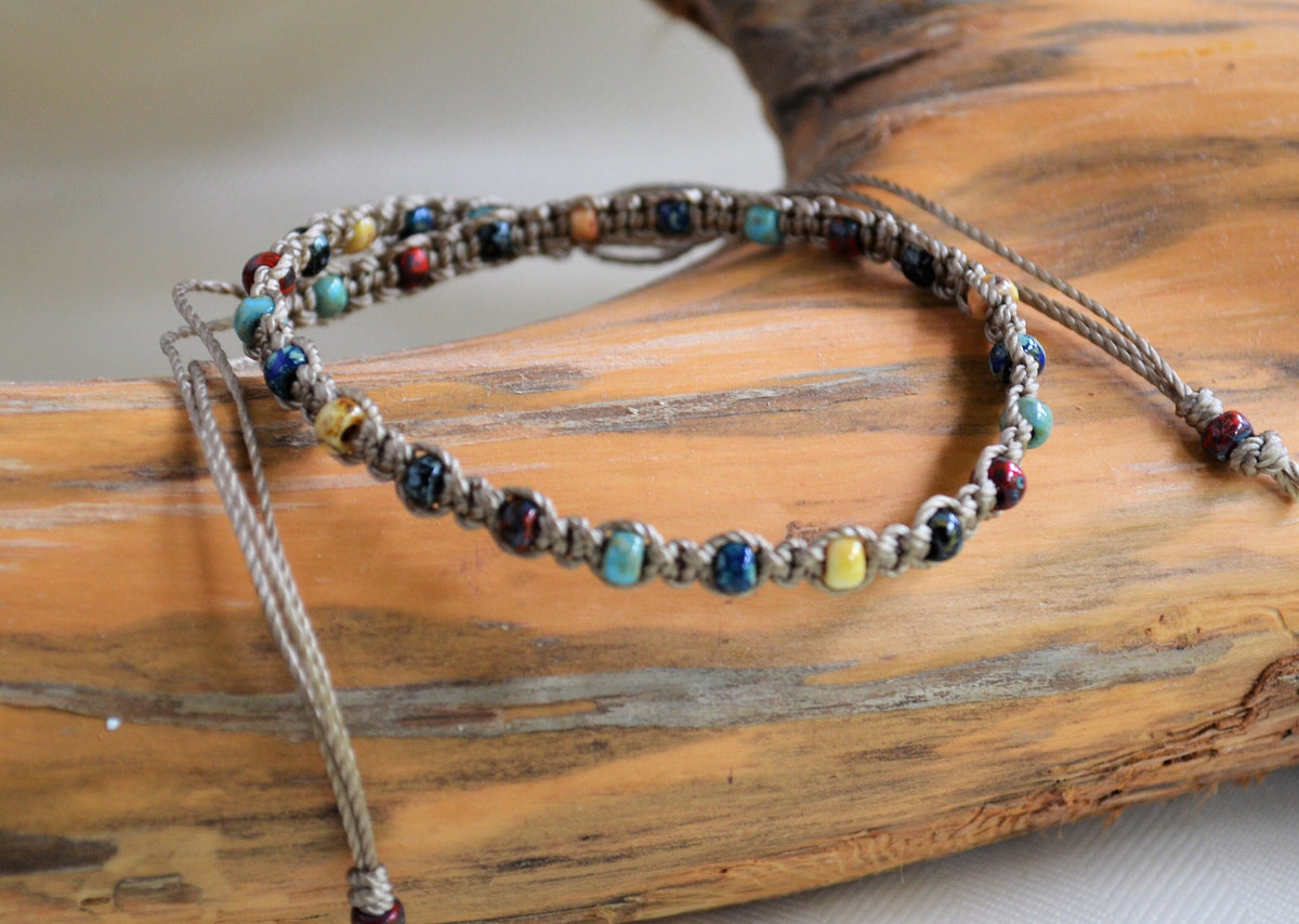 Multicolored beaded ankle bracelet on a wooden surface
