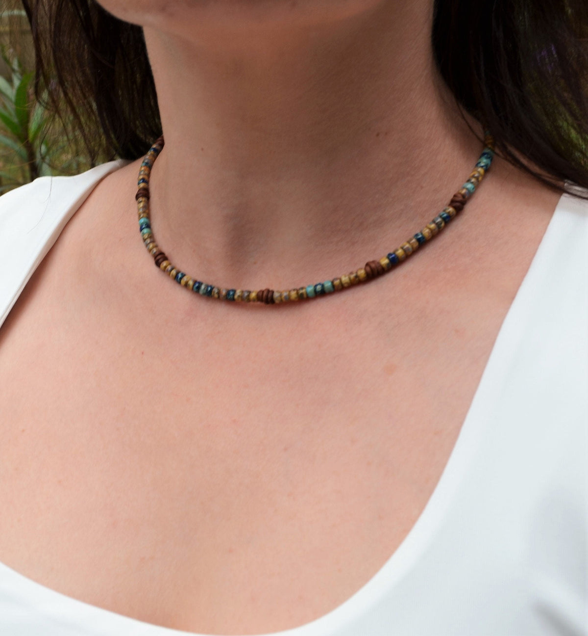 Close-up of a person wearing a colorful beaded necklace against a blurred background