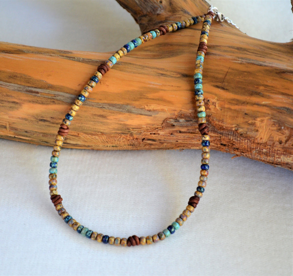 Multicolored beaded necklace on a piece of driftwood
