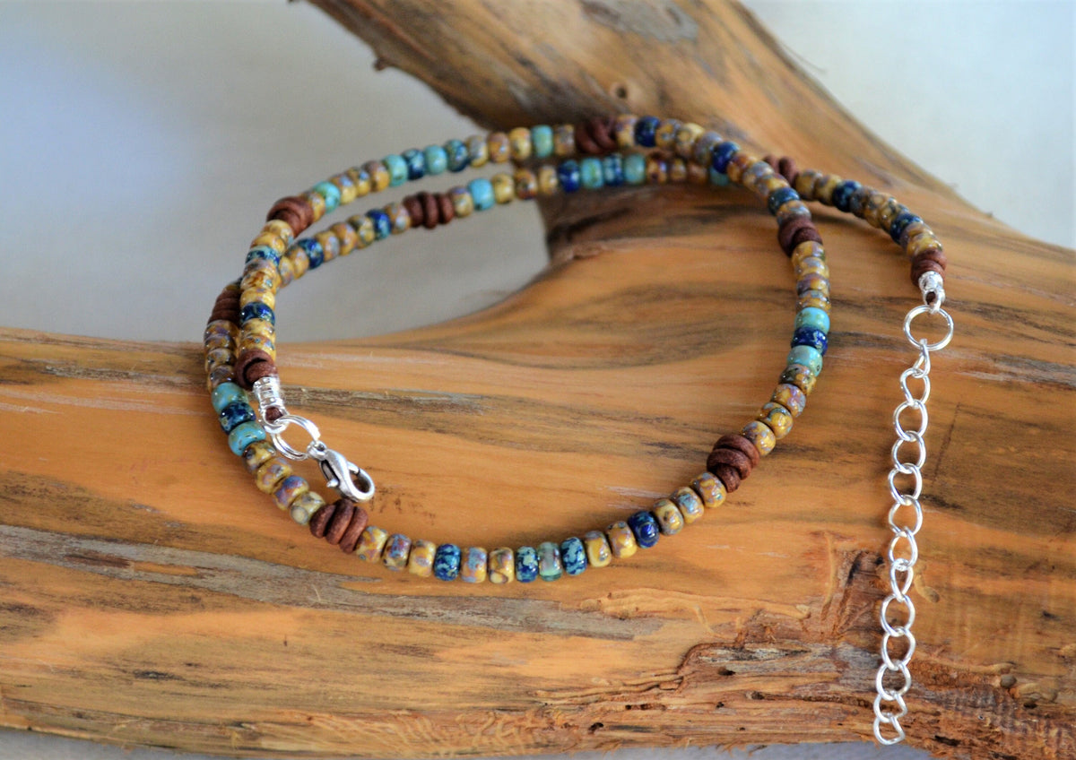 Beaded necklace with a silver clasp on a wooden surface