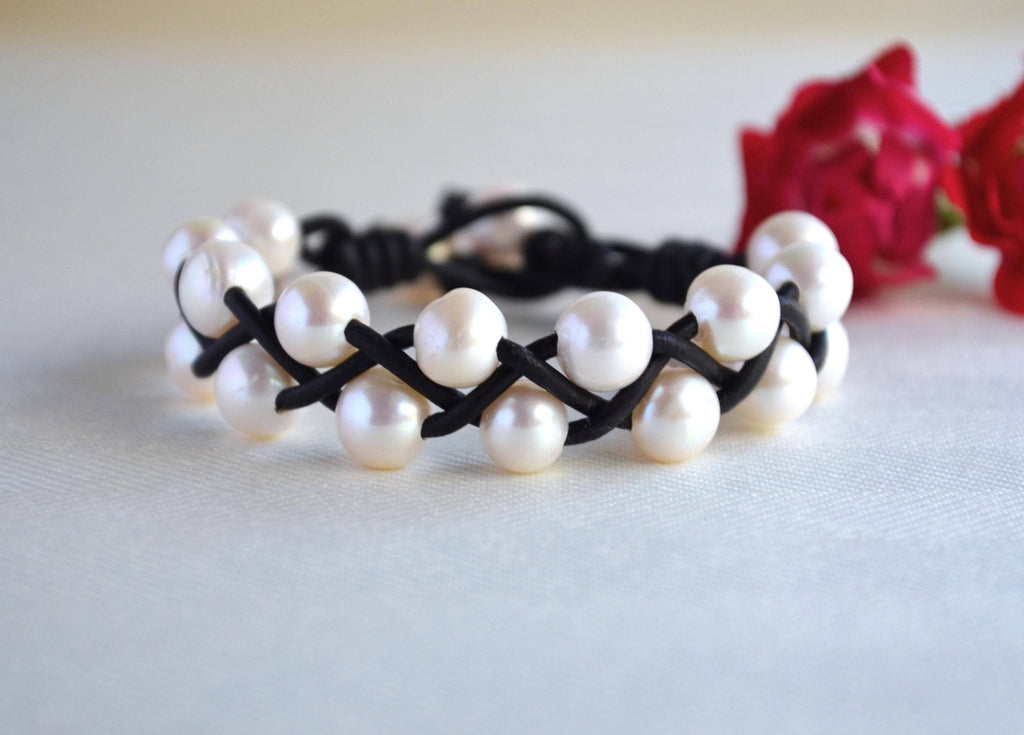 Pearl bracelet with black cord on a light background
