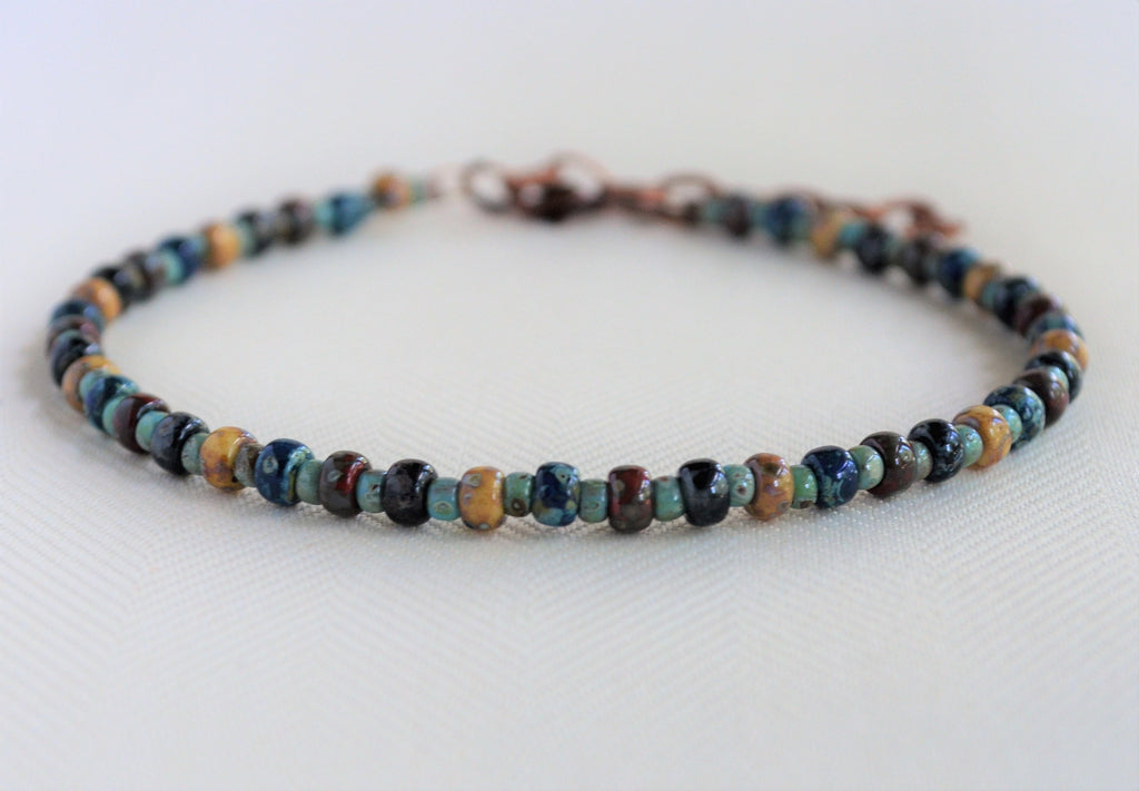Multicolored beaded ankle bracelet on a white background