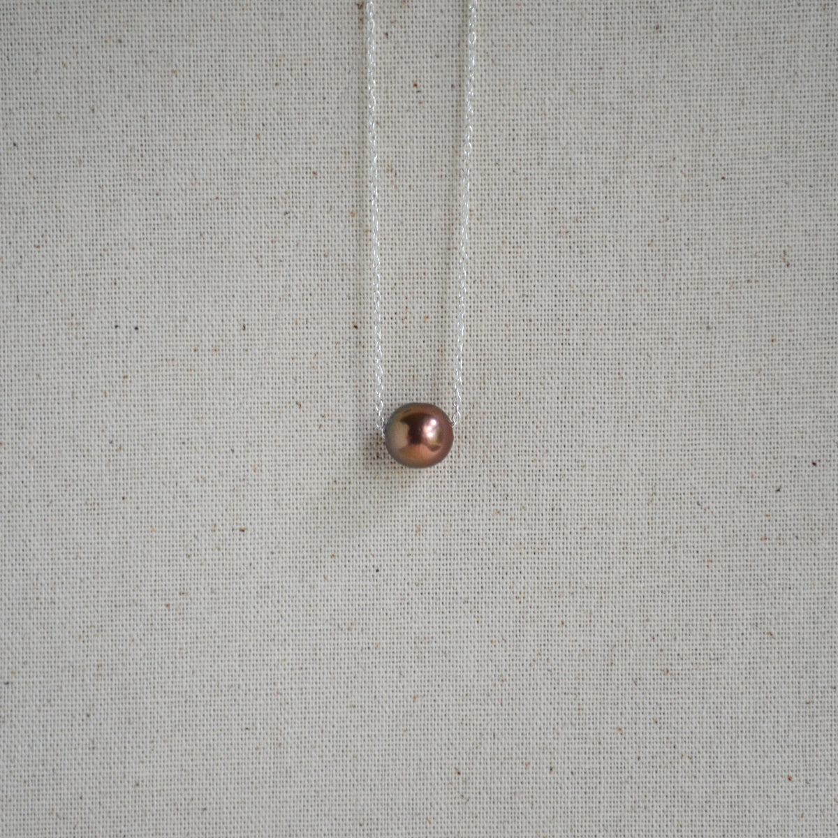 Chocolate Edison pearl floating necklace close-up, warm bronze luster, sterling silver chain