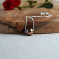 Chocolate Edison pearl necklace flat lay on white linen with red rose, sterling silver chain, JewelryByYevga