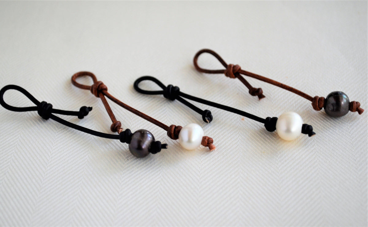 Four pearl leather necklace/bracelet extenders on a white background