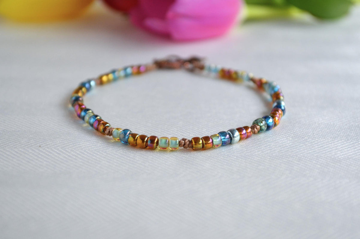 Multicolored beaded ankle bracelet on a light background