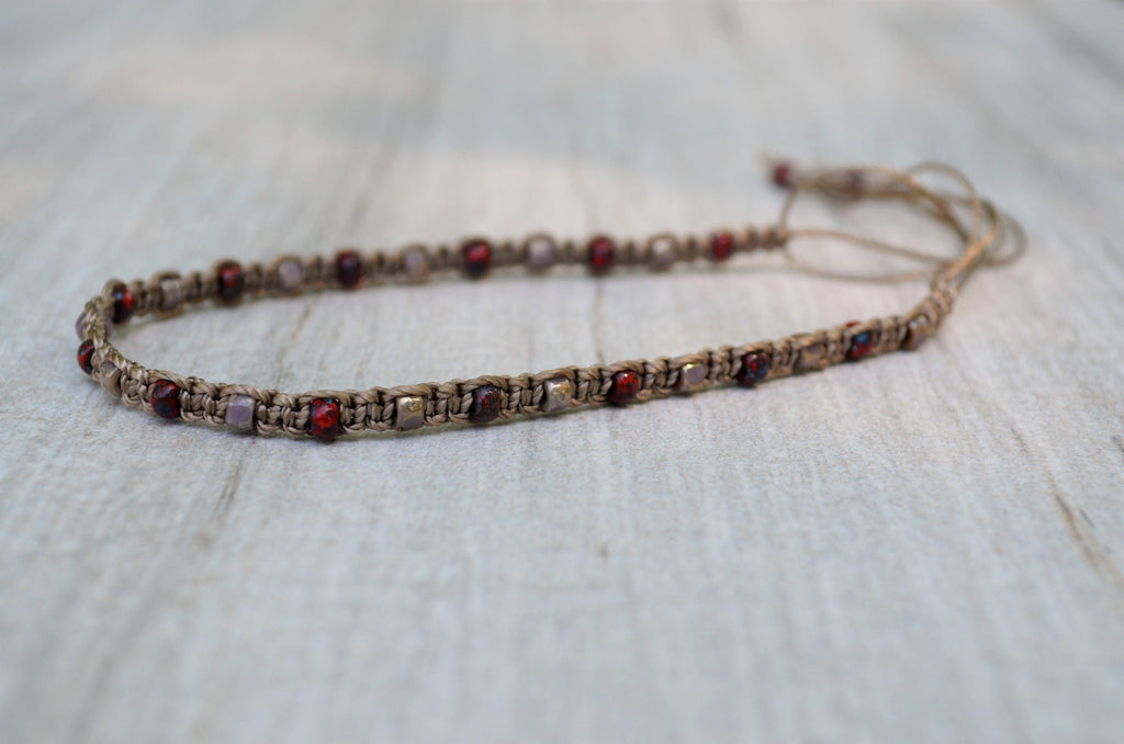 Beaded bracelet with red and pink beads on a light wooden surface