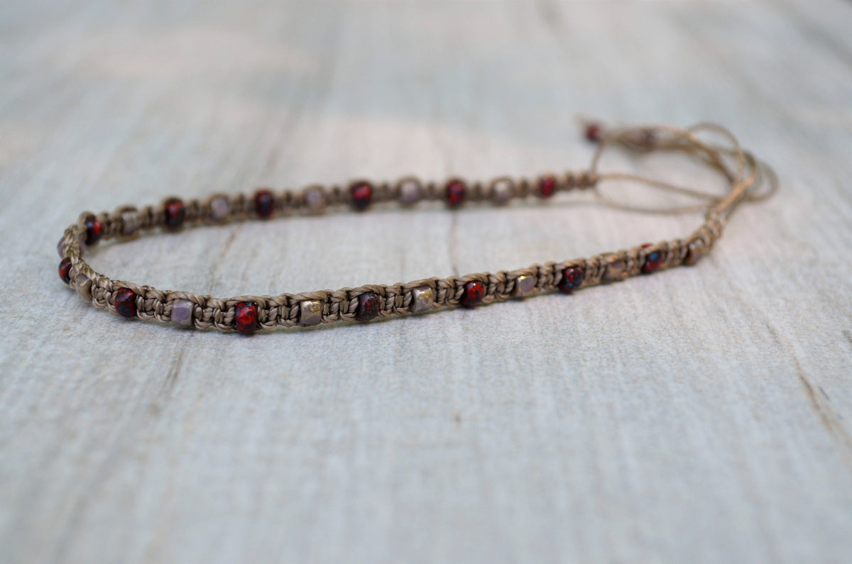 Beaded bracelet with red and pink beads on a light wooden surface