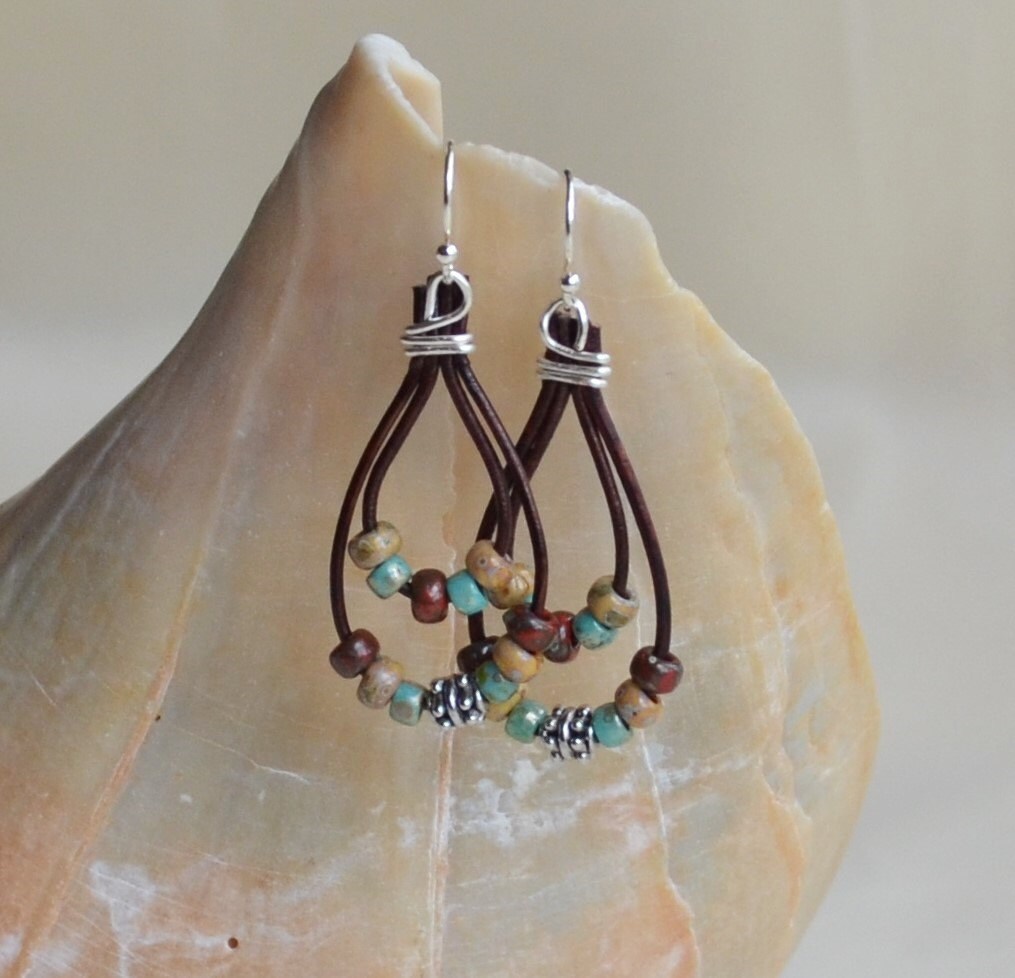 Pair of beaded earrings on a stone surface