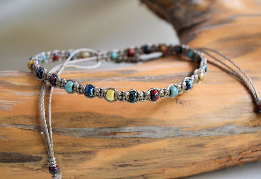 Multicolored beaded ankle bracelet on a wooden surface