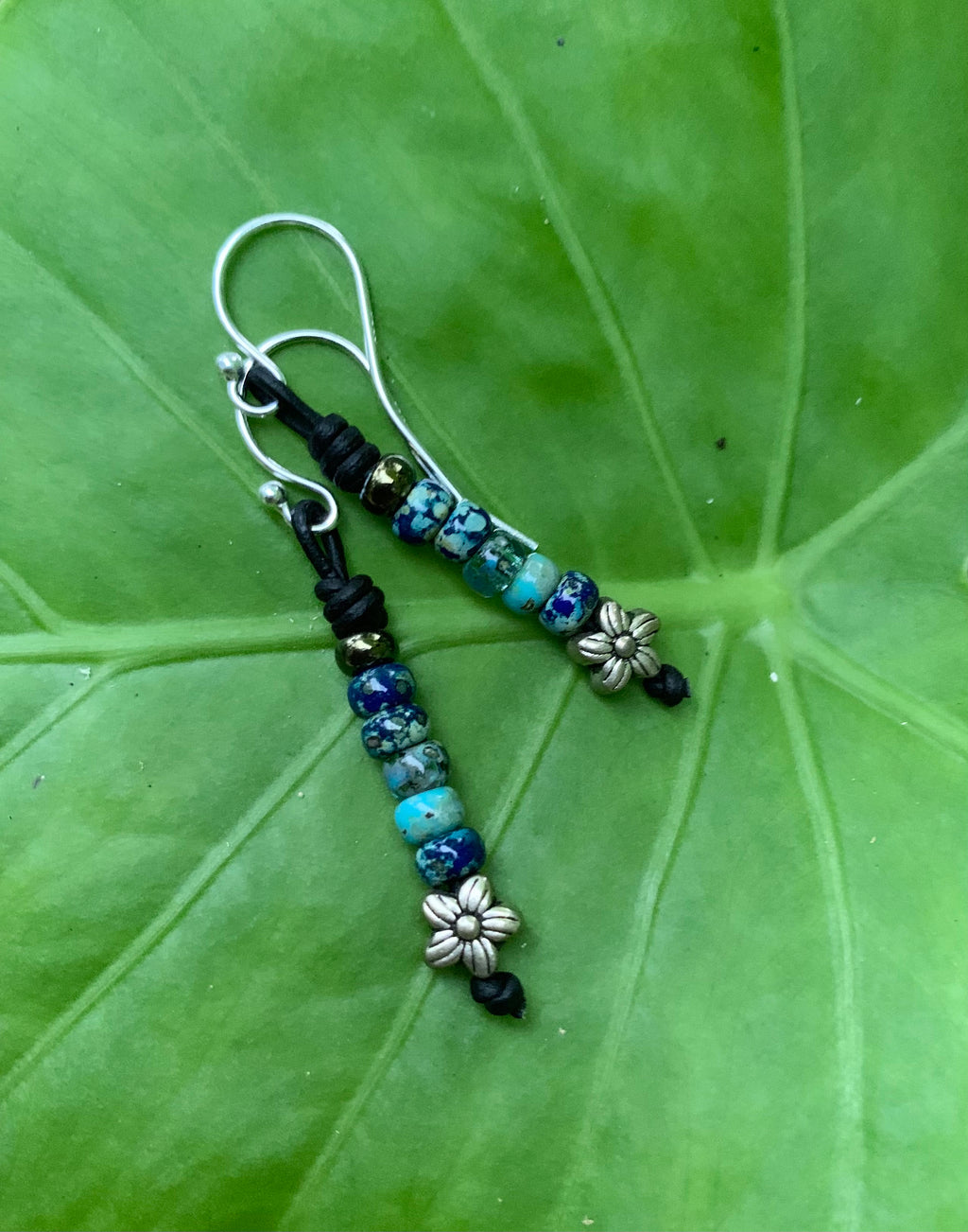 Beaded earrings on a green leaf