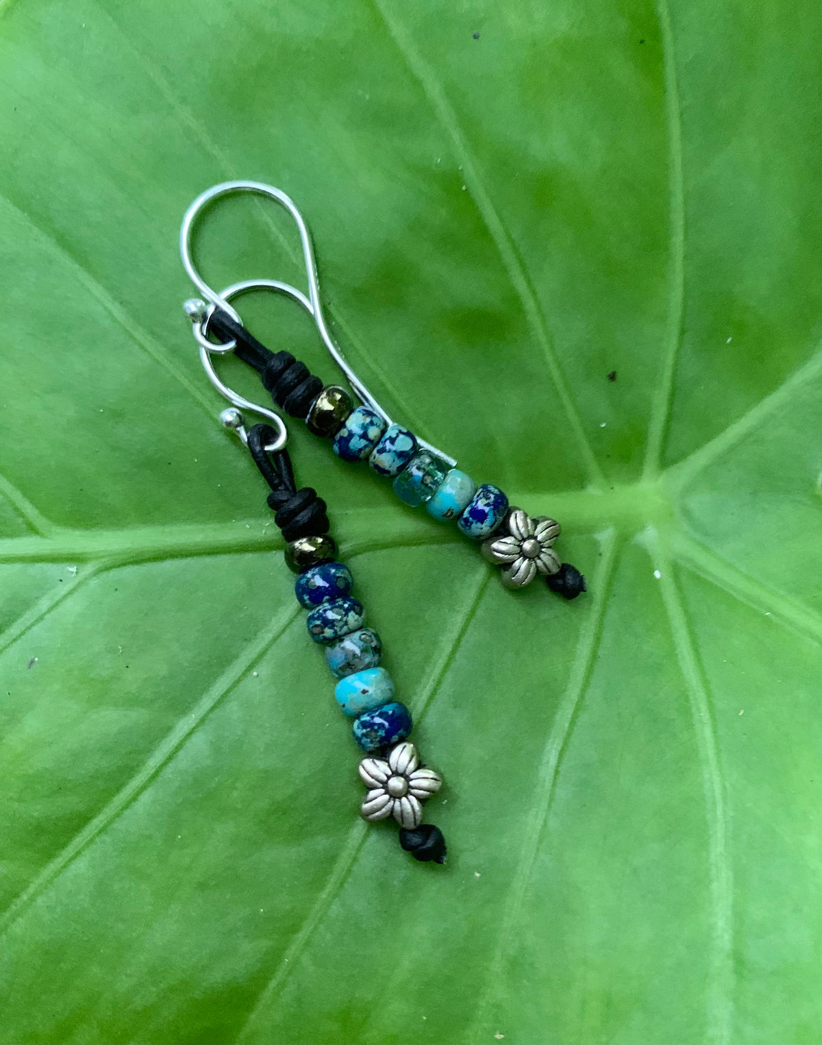 Beaded earrings on a green leaf